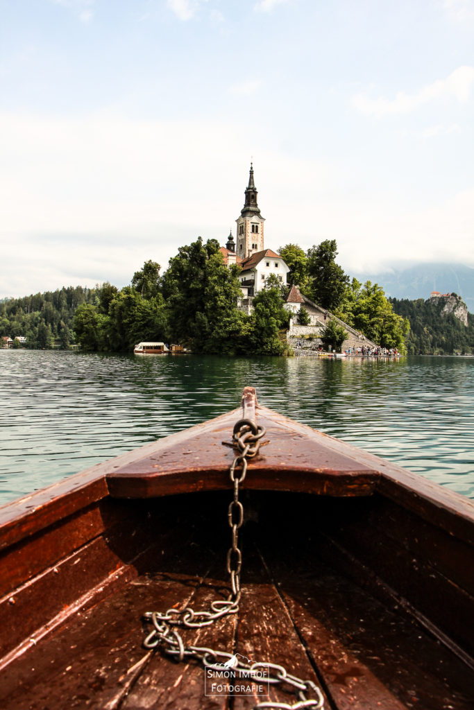 Blick vom Ruderboot aus auf die Insel mit Kirche im See von Bled, Slovenien
