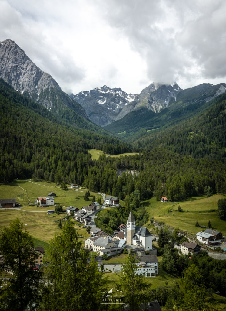 Blick vom Schloss Tarasp auf das klassische Engadiner Dorf mit den Bergen im Hintergrund, Schweiz, Graubünden, Landschaftsbild